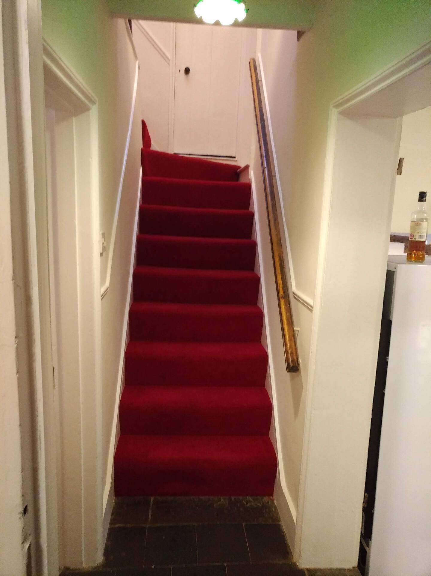Hallway with red carpeted stairs